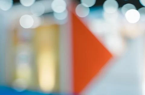 Vibrant abstract blurred background of red triangle and white bokeh lights Stock Photos
