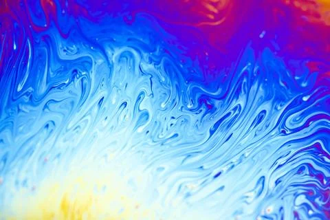 Vibrant abstract patterns of swirling blue and purple soap film iridescence 스톡 사진