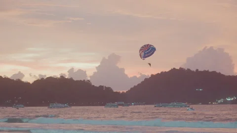 Vibrant aerial view at dusk. Dynamic coastal scene showcasing parasailing joy 스톡 동영상 335177247