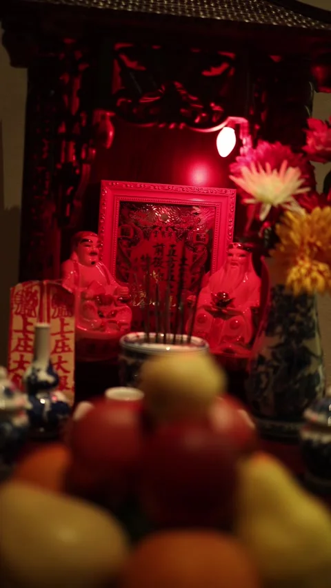 A vibrant altar illuminated with a warm red light, featuring traditional Chinese Stock Footage 293563882