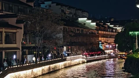 A vibrant and bustling night scene along a historic waterway in Nanjing, China 库存影片 338283335