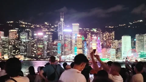 A vibrant and dynamic night scene of Hong Kong's skyline viewed from a Stock Footage 338280438