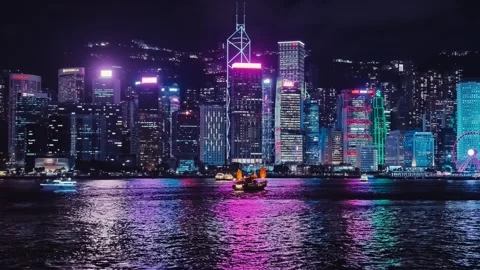 A vibrant and dynamic nighttime scene of Hong Kong's iconic skyline against the Stock Footage 338280501