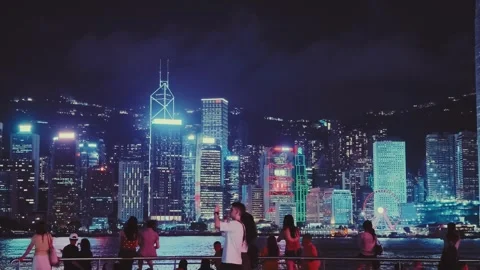 A vibrant and dynamic nighttime scene of Hong Kong's iconic skyline and bustling Stock Footage 338280505