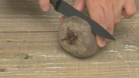 A vibrant and fresh Beetroot placed on a Wooden Surface, accompanied by a Knife Stockbeeldmateriaal 280692640