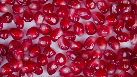 Vibrant arils on white background. Closeup of glossy ruby seeds with studio ligh Stock Footage 329503688