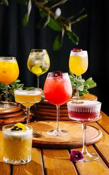 A vibrant array of cocktails is presented on round wooden coasters Foto stock