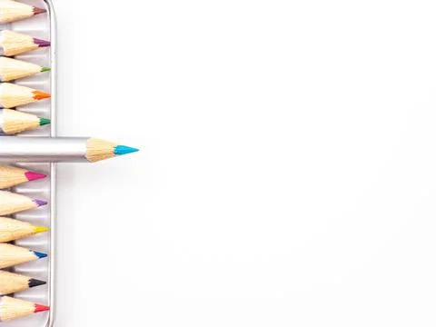 Vibrant array of colored pencils in a metal tin container against a white backgr Stock Photos