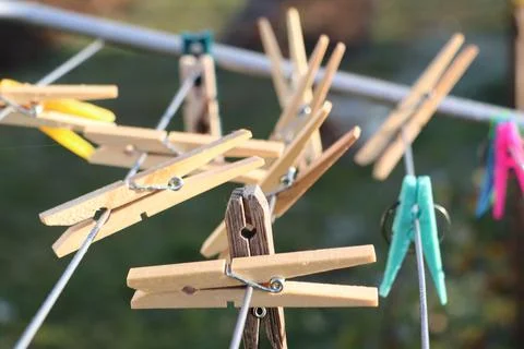 A vibrant array of colorful clothespins hanging on a clothesline illuminated by 스톡 사진