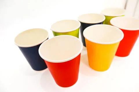 Vibrant array of colorful paper cups on a white surface, perfect for party .. Foto stock