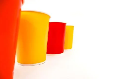 Vibrant array of colorful plastic cups in a row, isolated on a clean white .. Stockfoto's