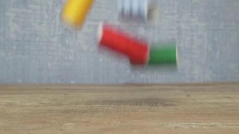 A Vibrant Array of Colorful Sewing Threads Laid Out on a Rustic Wooden Table Vídeo Stock 287454162