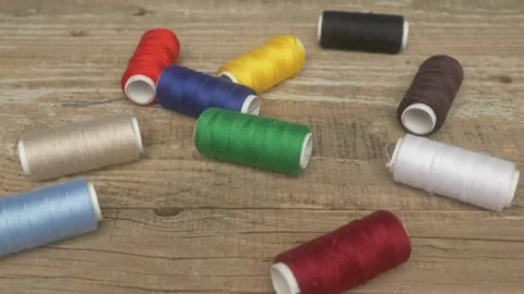 A Vibrant Array of Colorful Spools of Thread Displayed on a Rustic Wooden Table 스톡 동영상 287454207