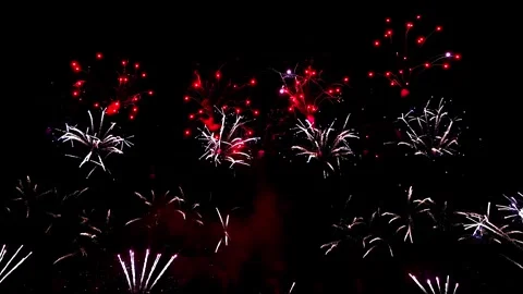 A vibrant array of fireworks bursts into the night sky, illuminating the Stock Footage 273315697