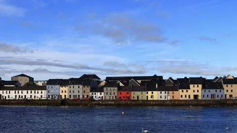 Vibrant array of houses in various bold colors, dotting the shoreline in Galway Stock Photos