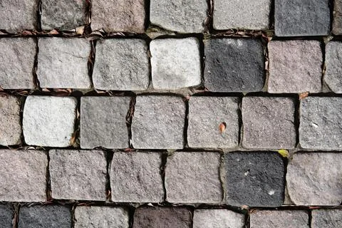 Vibrant array of hued stones are neatly stacked on a city sidewalk Foto stock