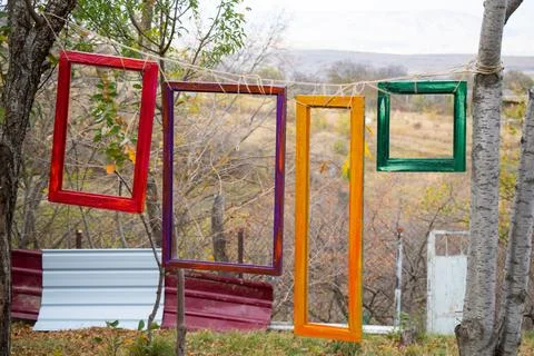 Vibrant array of picture frames hangs on a tree outdoors Foto stock