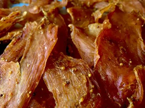 A vibrant array of thinly sliced dried meat showcases rich colors and textures. Stock Photos