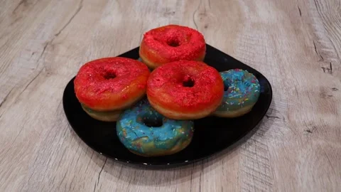 A vibrant assortment of colorful donuts adorned with a variety of toppings rests Stock Footage 344105994