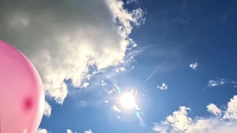Vibrant balloons rising slowly under the bright sun in clear sky Stock Footage 321241478