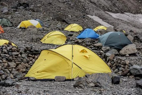 Vibrant Base Camp: A colorful array of tents sprawls across the rocky terra.. Stock Photos
