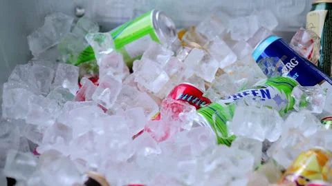 Vibrant beverage cans and bottles nestled in frosty ice, offering cool Stock Footage 301952589