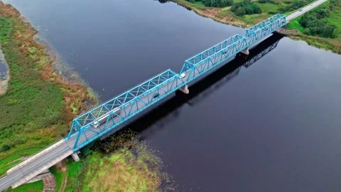 Vibrant blue bridge over tranquil waters in Latvia viewed from above Stock Footage 319551632