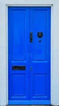 Vibrant Blue Door With Black Metal Features Stock Photos