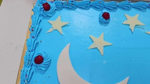 A vibrant blue Eid Mubarak cake, adorned with white stars Stock-Footage 311584459