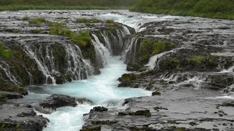 Vibrant Blue Glacial Water Cascading over Basalt Rocks at Brúarfoss in Iceland Stockbeeldmateriaal 339967656