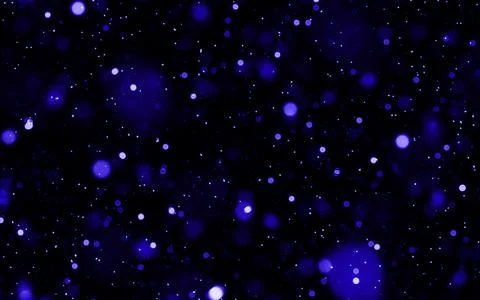 Vibrant blue glowing particles floating against a dark background Stock Photos