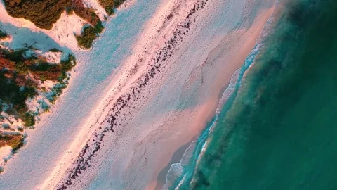 Vibrant Blue Ocean and Warm Pink Sandy Shore Aerial Drone View at Golden Hour Stock Footage 339090782