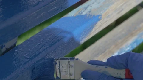 A Vibrant Blue Paint Application Technique on a Wooden Surface for Creative Stock Footage 286123913