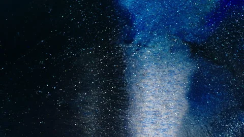 Vibrant Blue Particles Dissolving in Liquid Macro Shot Stock Footage 317848568