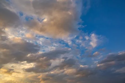 A vibrant blue sky features dynamic gray and white clouds illuminated with .. Foto stock