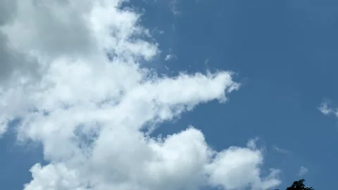 Vibrant blue sky with fluffy white clouds creating a serene and peaceful at.. Stock-Footage 339295981