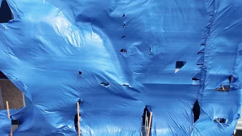 Vibrant blue tarp billowing in the wind against an urban backdrop. Stock-Footage 334653079