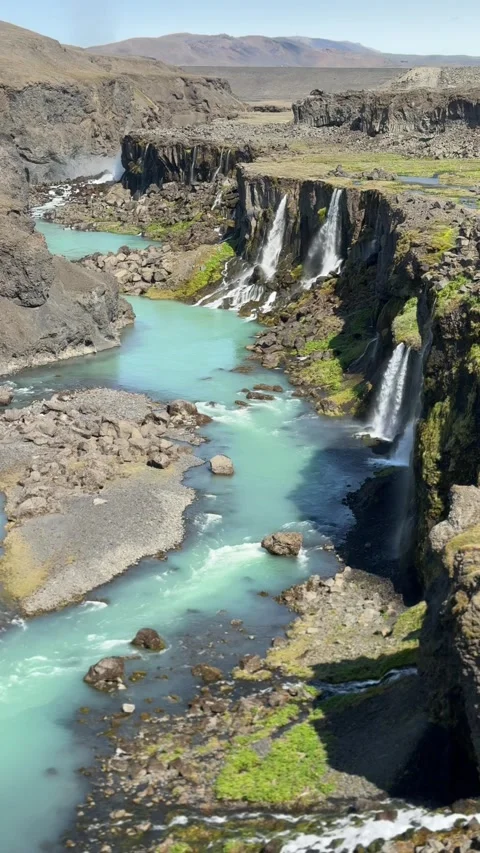 Vibrant blue waters wind through Sigöldugljúfur canyon in Iceland, framed by nar Stock Footage 312232760
