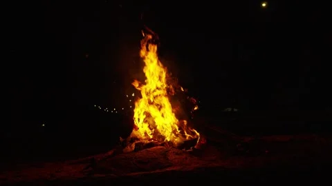 A vibrant bonfire blazes at night, providing light and warmth outdoors 스톡 동영상 336446035