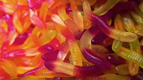 Vibrant candy store close-up showing gummy worms in assorted fruit colors, with Stock Footage 339847277
