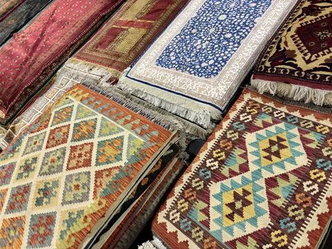 Vibrant Central Asian patterned rugs and carpets displayed on a floor. Stock Photos