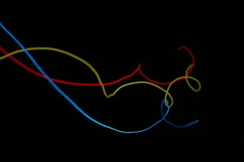 A vibrant, chaotic closeup of tangled multicolor glowing EL wire Stock Photos
