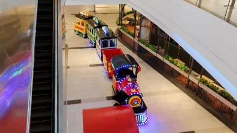 A vibrant children's train with bright lights displayed in a shopping mall Stock Footage 304062101