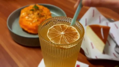 Vibrant Citrus Lemon Squash With Dried Orange Slice Ice Cubes And Straw Stirring Stock Footage 319826800