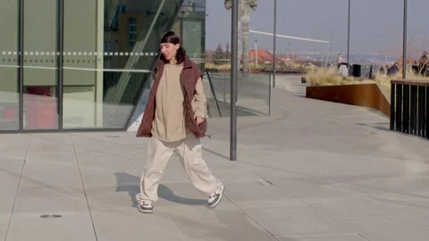 A vibrant city scene features dancing, walking, and energy near a bridge Stock Footage 311133953