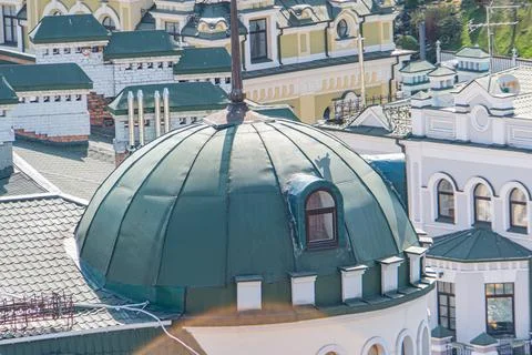 Vibrant cityscape, clear sky, large dome structure with green roof, contras.. Stock Photos