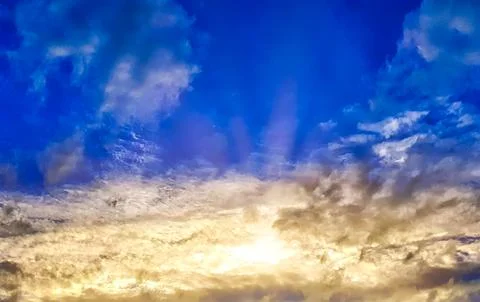 Vibrant Cloudy Sky with Sun Rays During Sunset Stock Photos