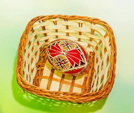 Vibrant colored easter eggs in a brown basket Stock Photos