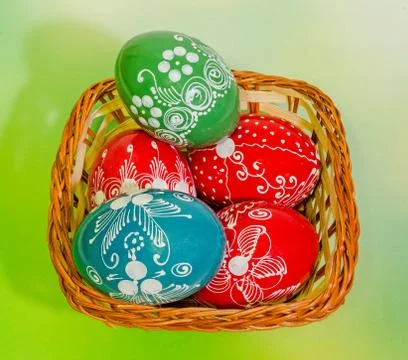 Vibrant colored easter eggs in a brown basket Stock Photos