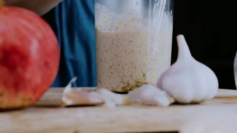 Vibrant culinary presentation: mixing spices into creamy walnut sauce Stock Photos